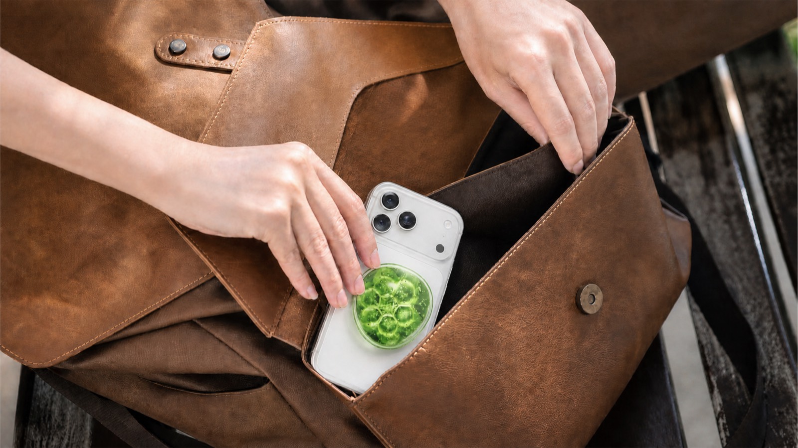 vuvu attached to a phone as it is placed into a bag